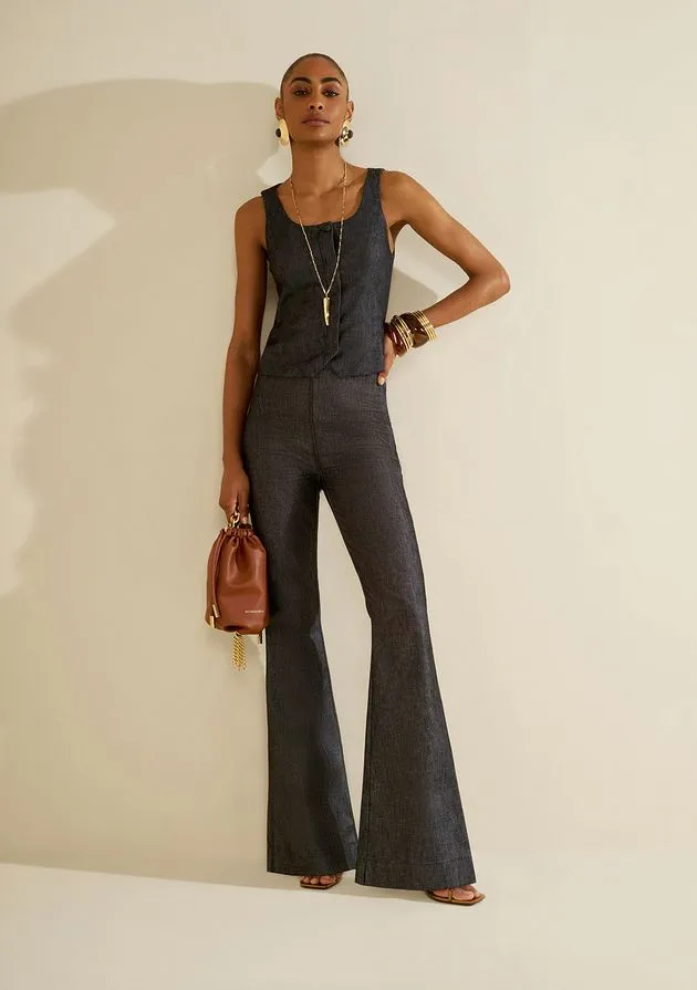 Modelo usando conjunto de colete e calça flare em jeans escuro