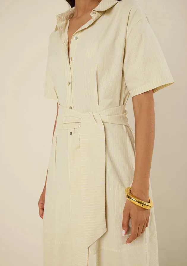 Detalhe da faixa amarrada e dos botões de um vestido chemise off-white